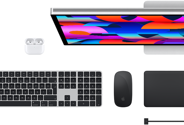 Mac aksesuarlarının üstten görünümü: Studio Display, AirPods, Magic Keyboard, Magic Mouse ve Magic Trackpad