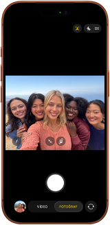 Kozmik Turuncu iPhone 17 Pro’nun önden görünümü, ekranda Center Stage ön kameranın açık olduğu ve beş kişinin bulunduğu grup selfie’sinde kadrajın ortalandığı gösteriliyor